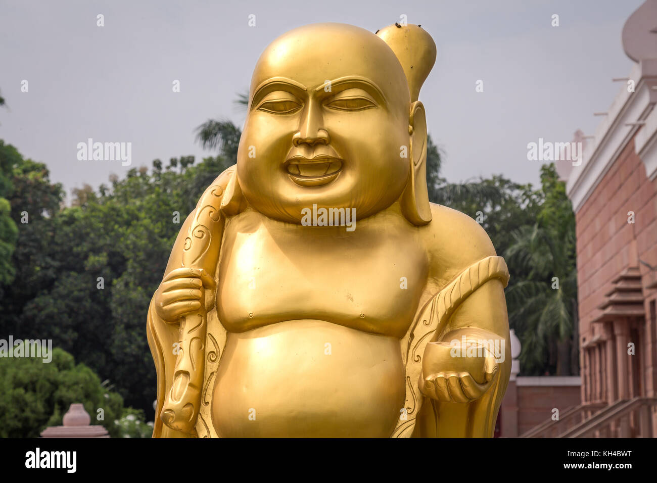 Golden laughing Buddha sculpture at Wat Thai Buddhist monastery at Sarnath, Varanasi Stock Photo