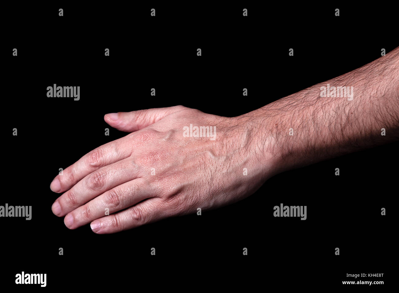 Male hand reaching or pointing down. Black background. Concept for salvation rescue friendship guidance help helping hands reaching down hope rescue Stock Photo