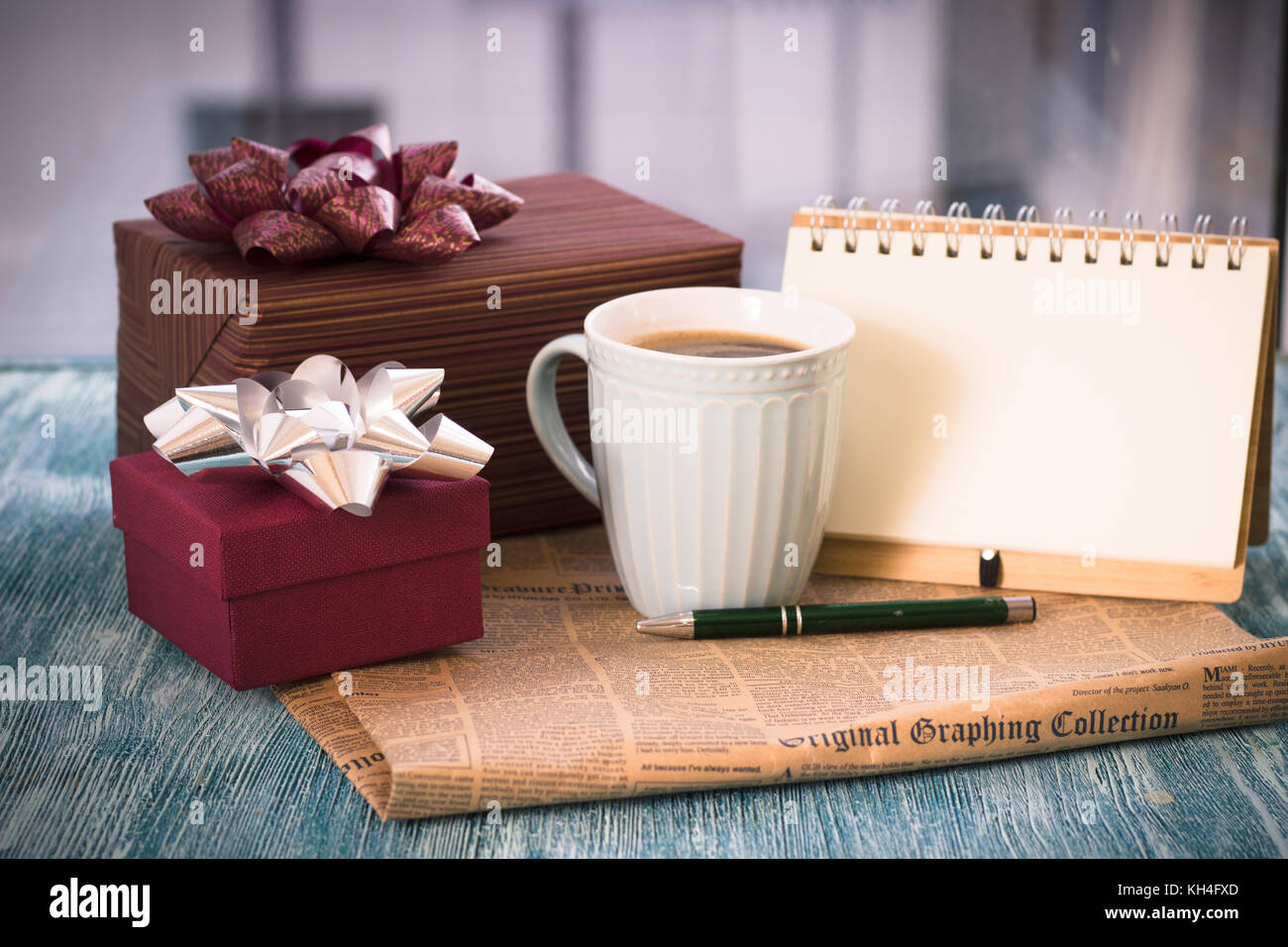 Festive still life with gifts, a cup, a notebook with a pen Stock Photo