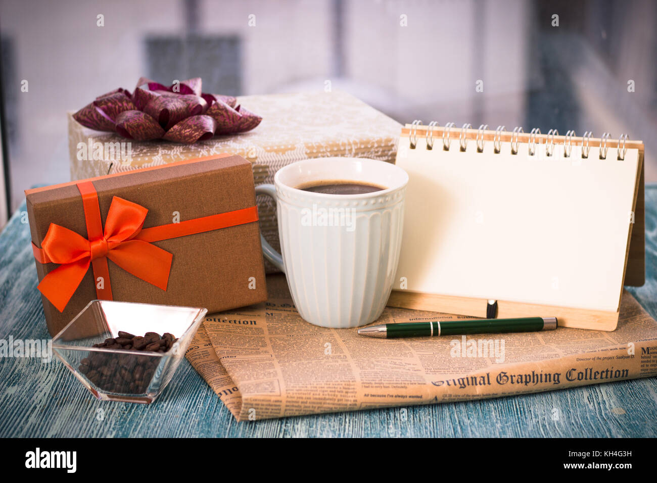 A festive still-life with presents, a cup, a vase, a notebook Stock Photo