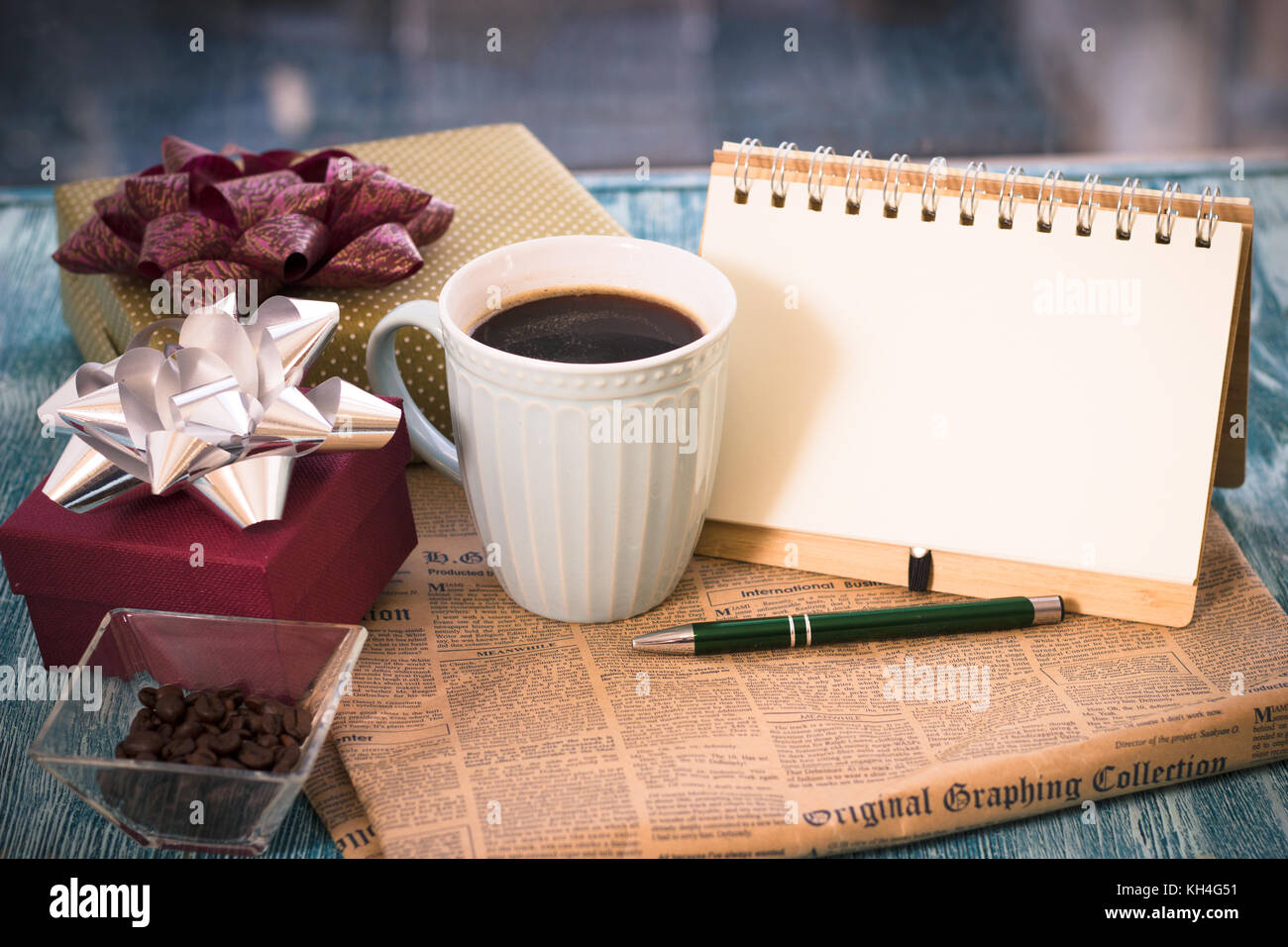 A festive still-life with presents, a cup, a vase, a notebook  Stock Photo