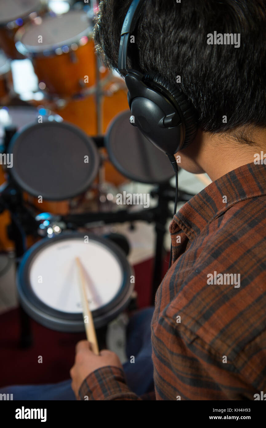 Young blond caucasian boy plays drums in shop, france Stock Photo
