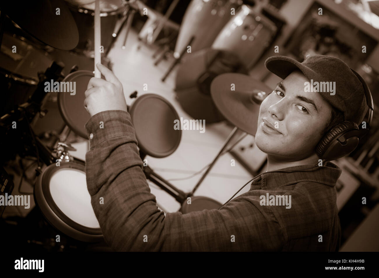 Young blond caucasian boy plays drums in shop, france Stock Photo