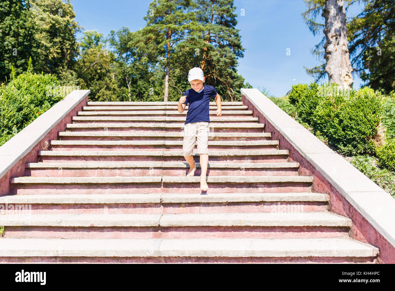 Boy going down on stairs barefoot. Concept childhood image with copy space Stock Photo