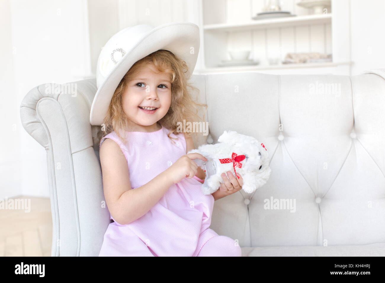 Charming girl in dress posing with toy Stock Photo