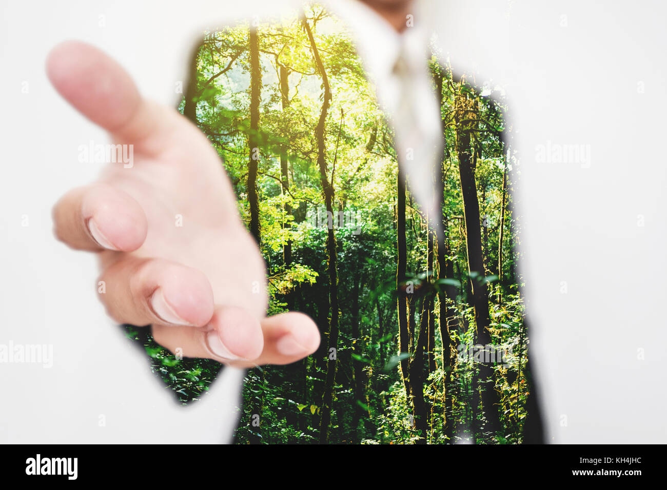 Double exposure, Businessman stretching hand to hand shake with Green trees in the forest. Eco friendly and sustainable business Stock Photo