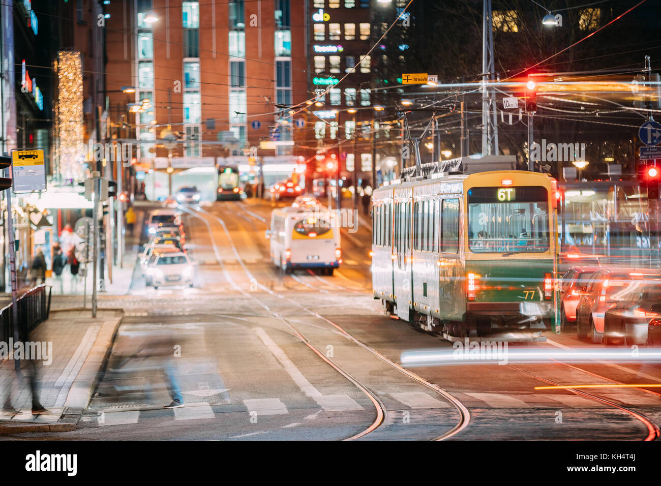 Helsinki, Finland. Tram Departs From A Stop On Kaivokatu Street In Helsinki. Night View Of Kaivokatu Street In Kluuvi District In Evening Or Night Ill Stock Photo