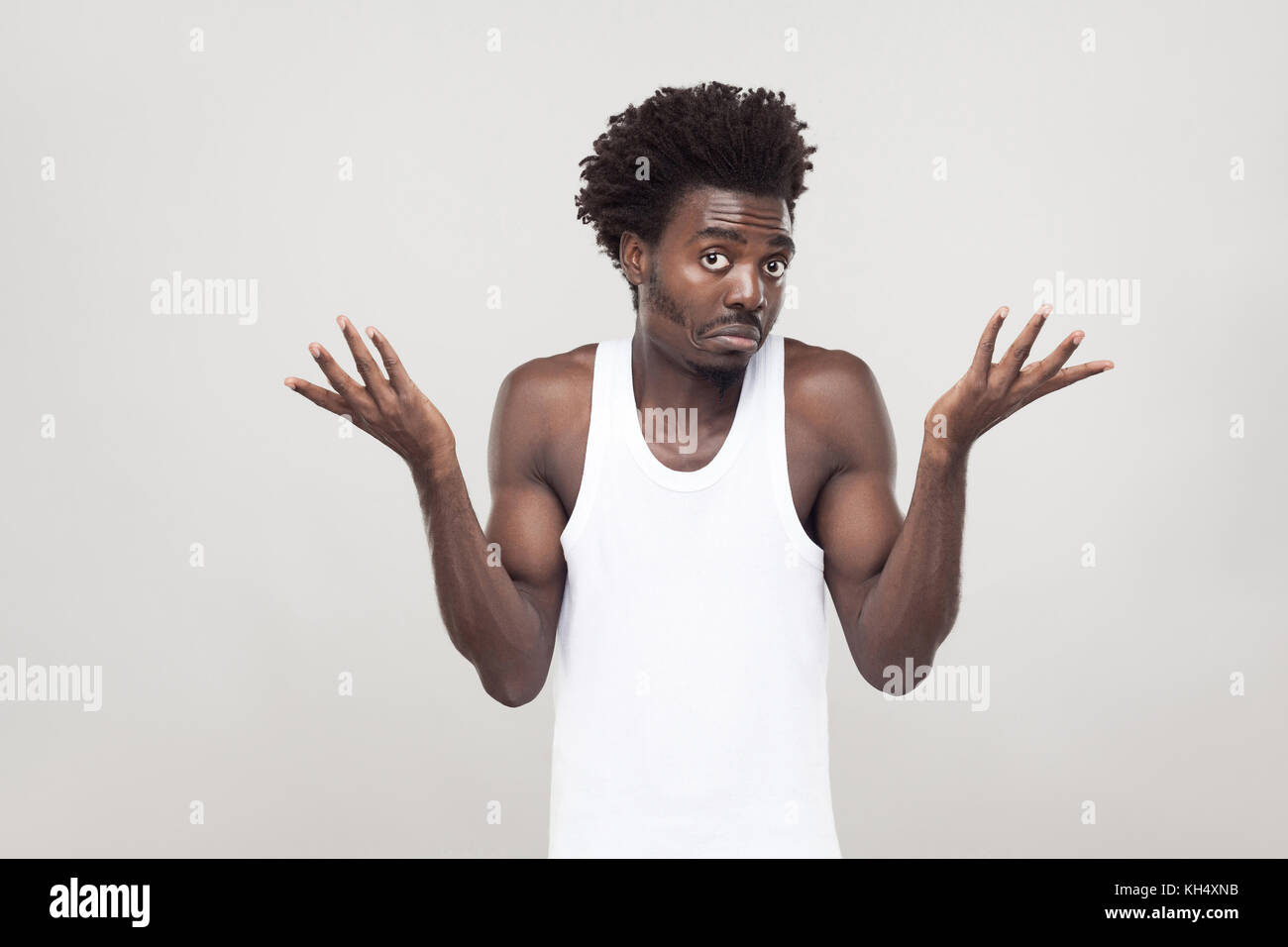 Emotional afro man have a confused look. Studio shot. Gray background Stock Photo