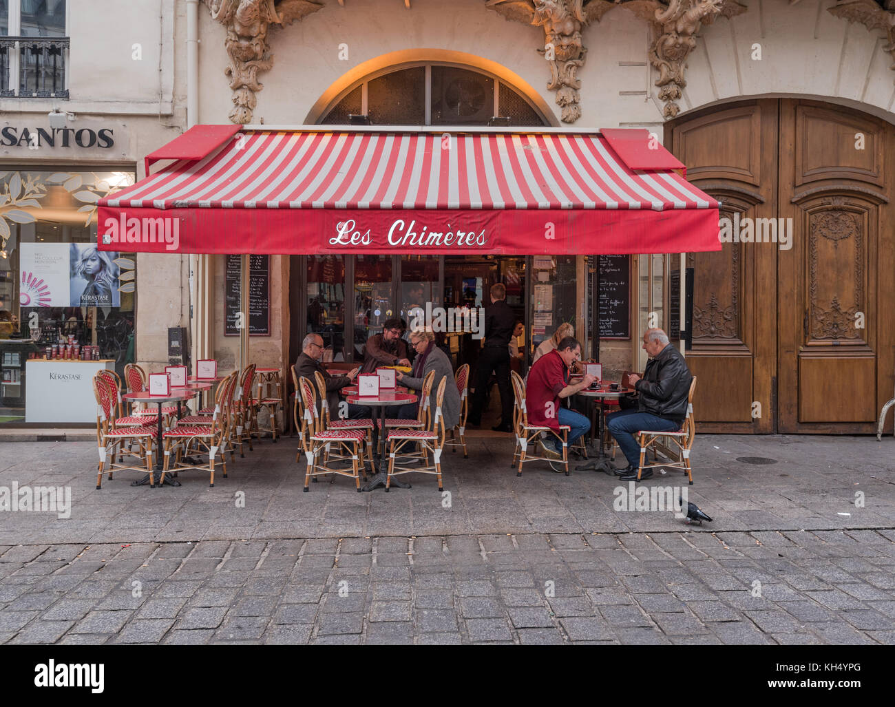 Paris, France -- November 4, 2017--People are enjoying coffee and snacks outdoors in a Parisian cafe. Editorial Use Only. Stock Photo
