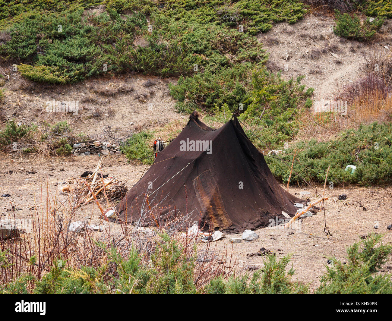 A simple tent made from traditional yak-wool blankets at a high-altitude grazing camp near Ghusang in the Annapurna Himalayas of Nepal Stock Photo