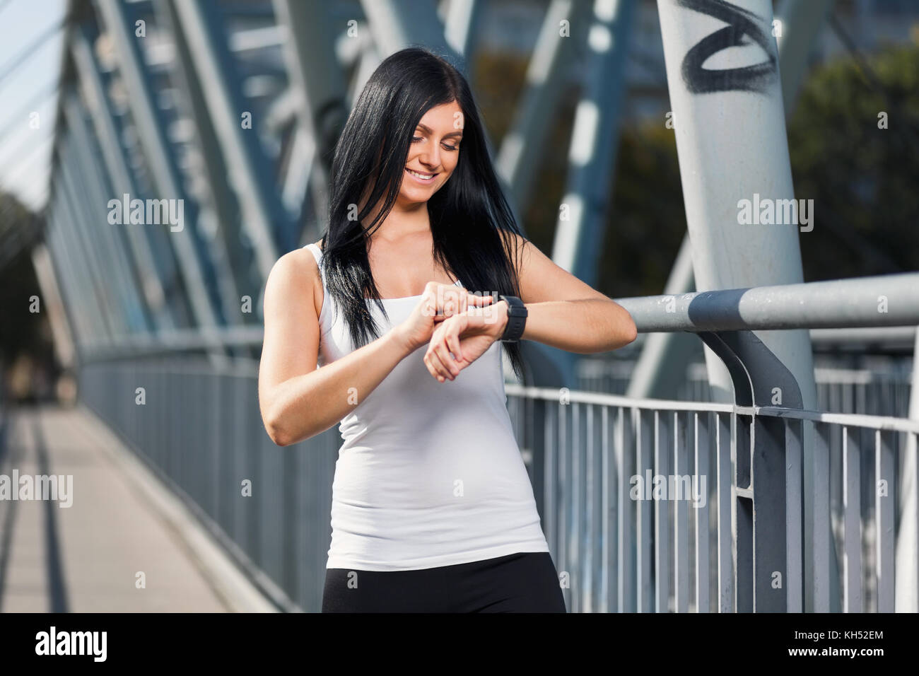 City workout. Beautiful young woman with a smartwatch training in an urban setting Stock Photo