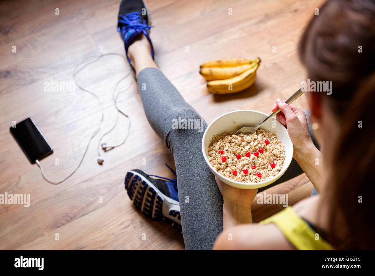 Young girl eating a oatmeal with berries after a workout . Fitness and