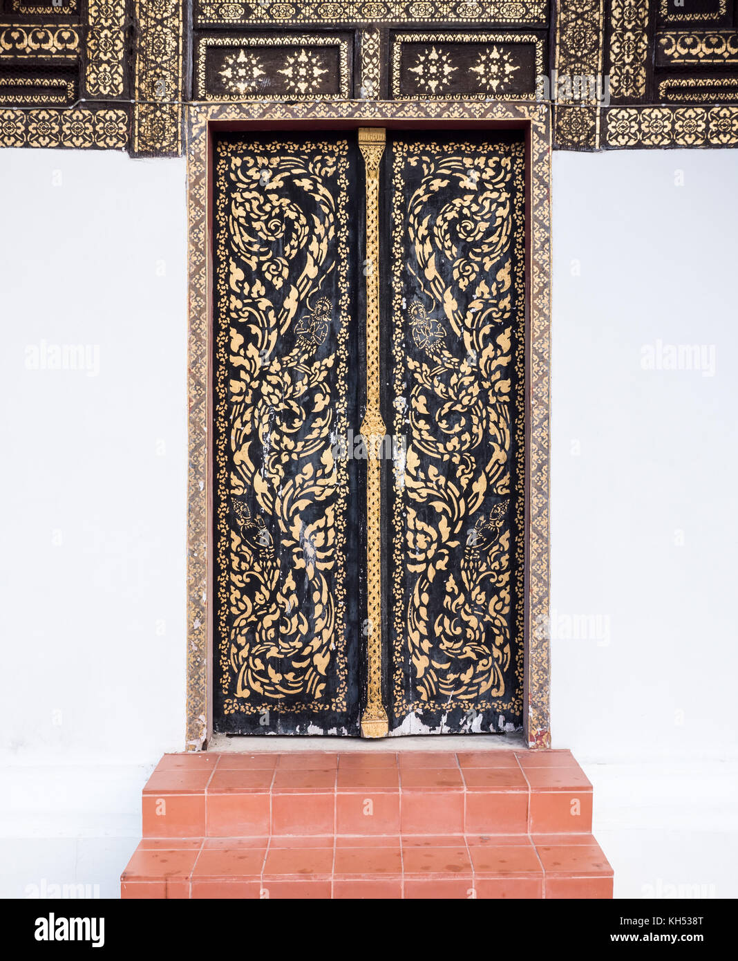 Old wooden door with the traditional Thai pattern of the local Thai