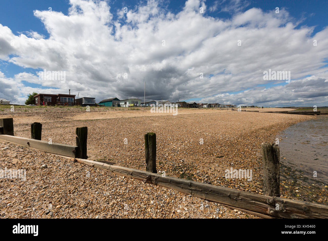 Beautiful, dramatic cloudscape over the huts and the shingle beach at Seasalter, Kent, UK. Stock Photo