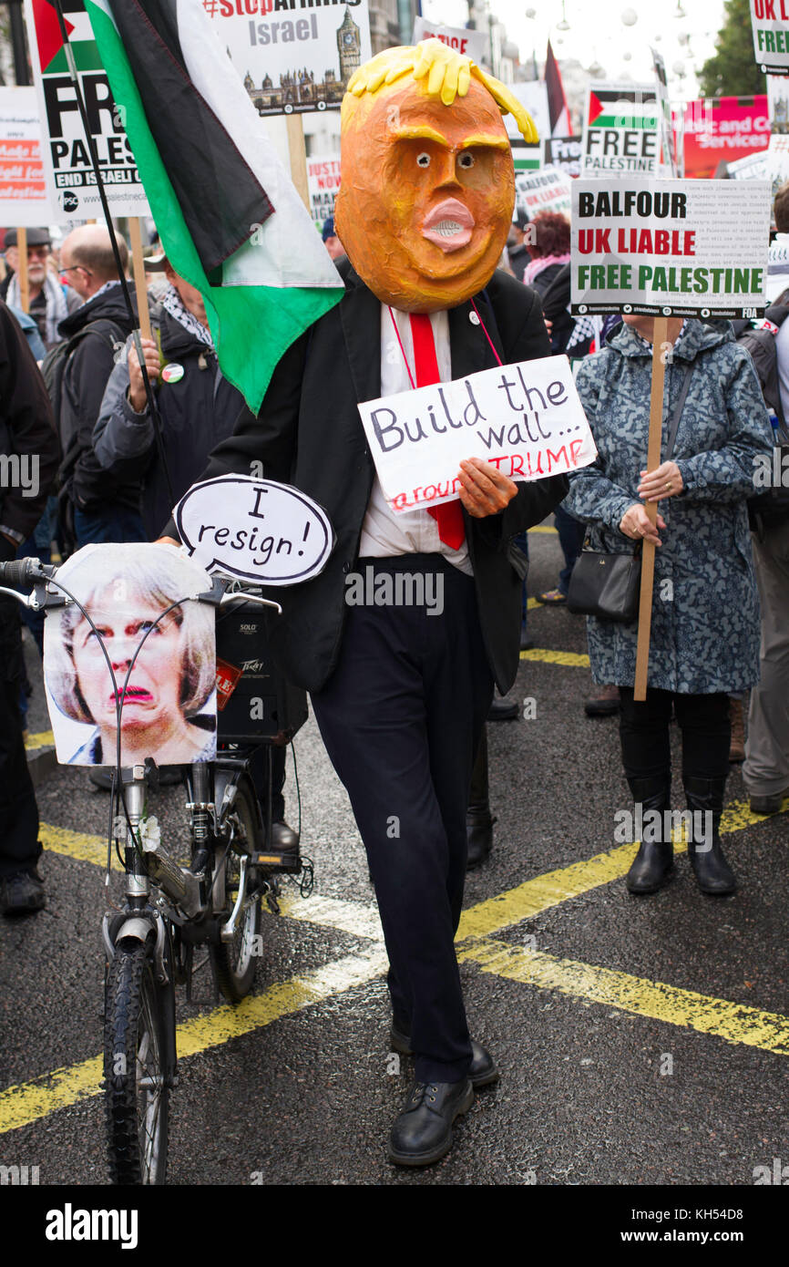 A long-time protestor sports a homemade Trump mask and 'Maybike' on the march for Palestine through London on the centenary of the Balfour Declaration Stock Photo