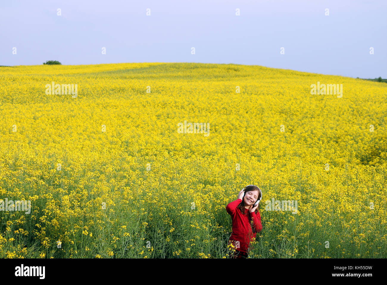 happy little girl enjoy in music on yellow field summer season Stock ...
