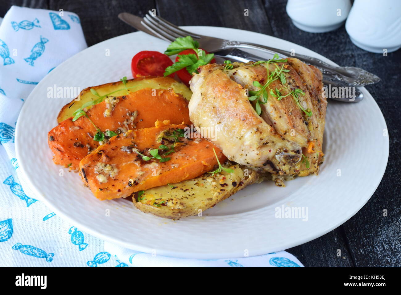 Oven cooked chicken with potato and sweet potato, spices , herbs in olive oil. Home cooking, healthy food concept Stock Photo