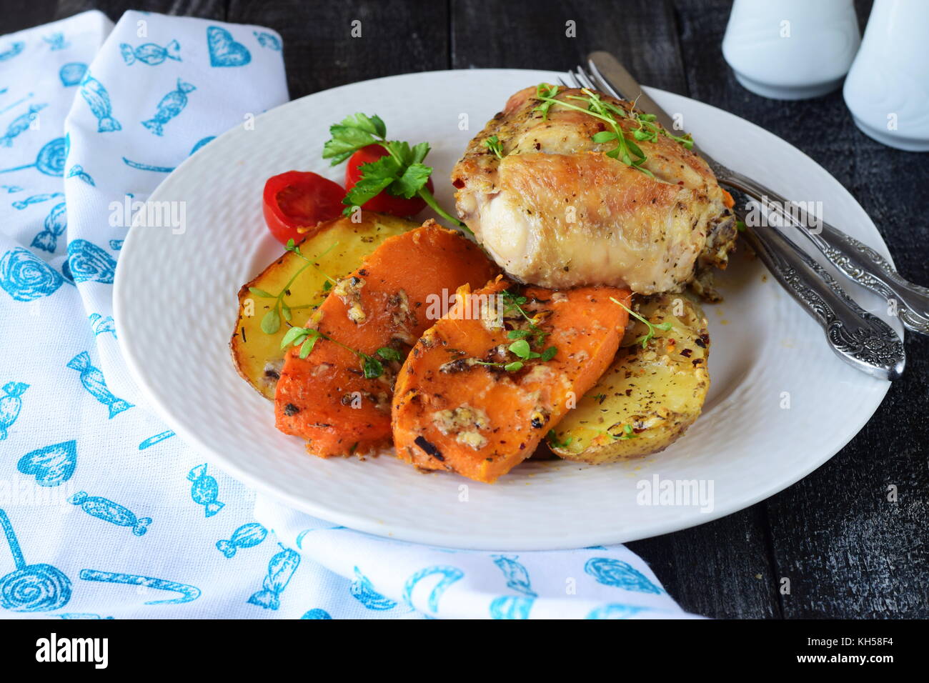 Oven cooked chicken with potato and sweet potato, spices , herbs in olive oil. Home cooking, healthy food concept Stock Photo