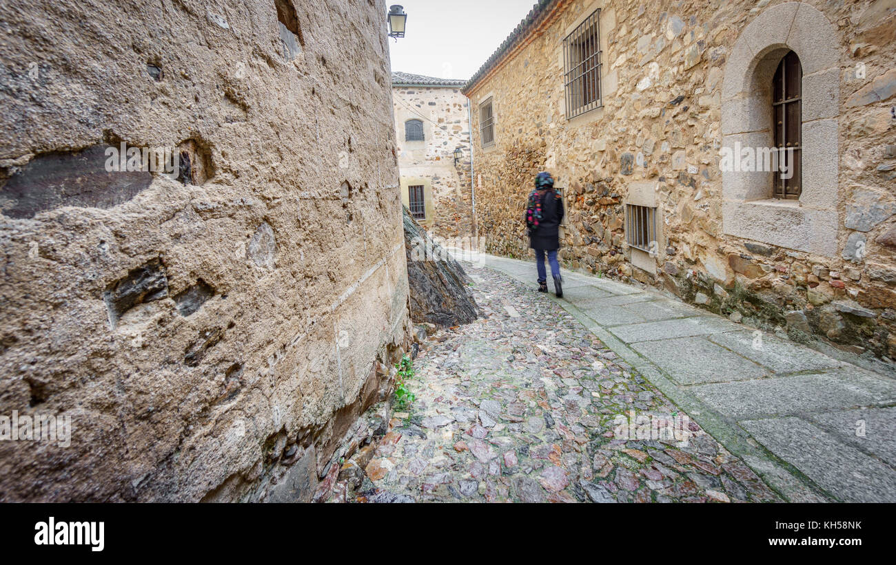Blurred tourist walking along small streets and large historical buildings, Caceres Stock Photo