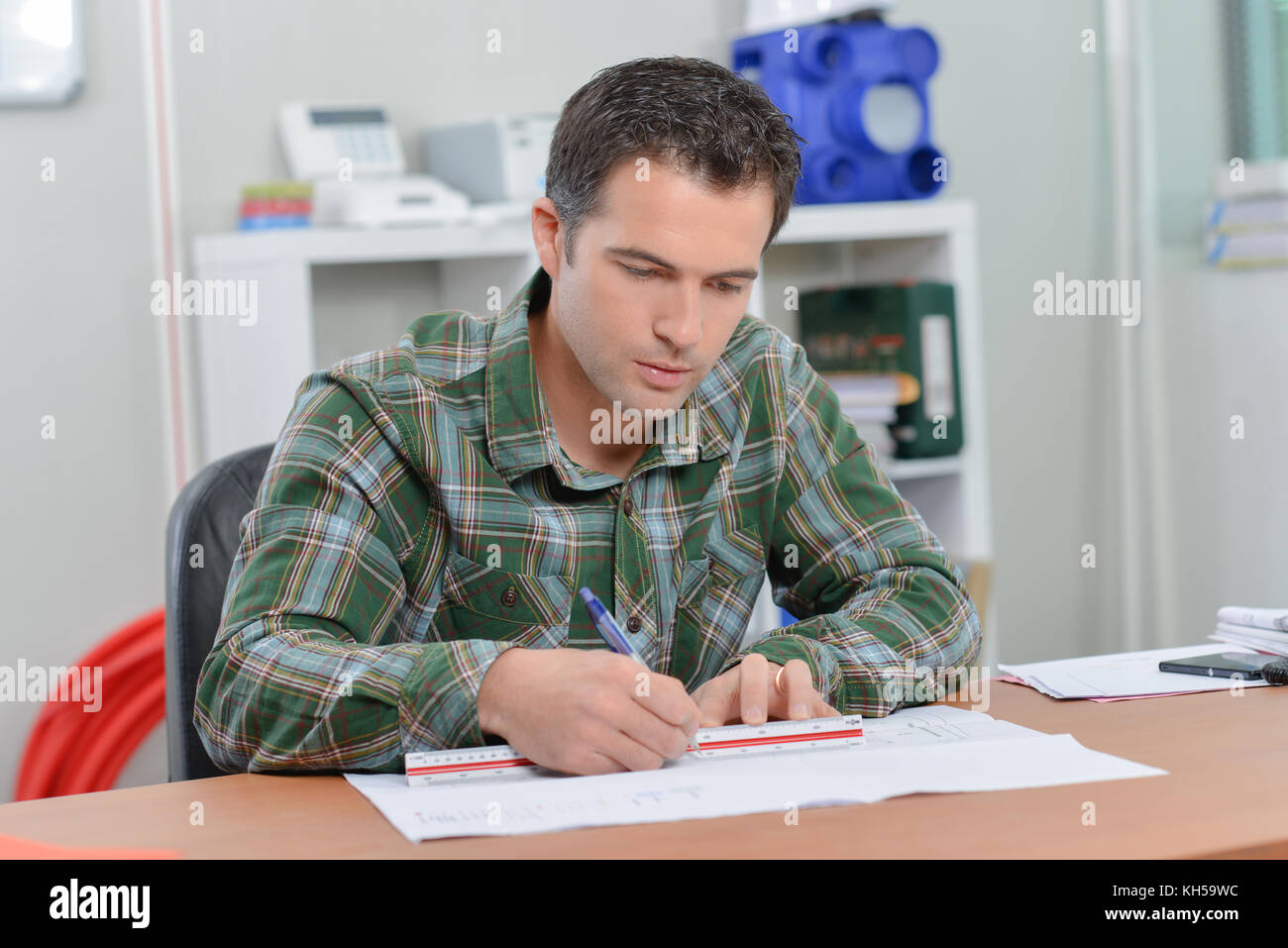 Architect sat drawing at his desk Stock Photo Alamy