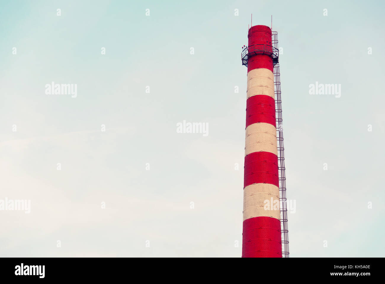 Red and white chimney on a blue sky background Stock Photo - Alamy