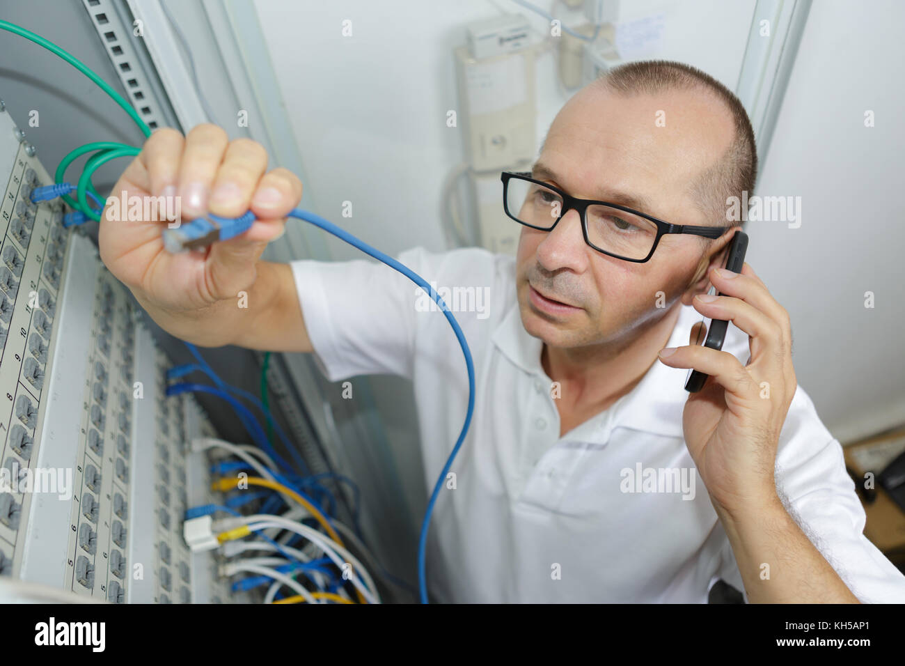 Phone Tech Team technician on the phone in server room Stock Photo - Alamy