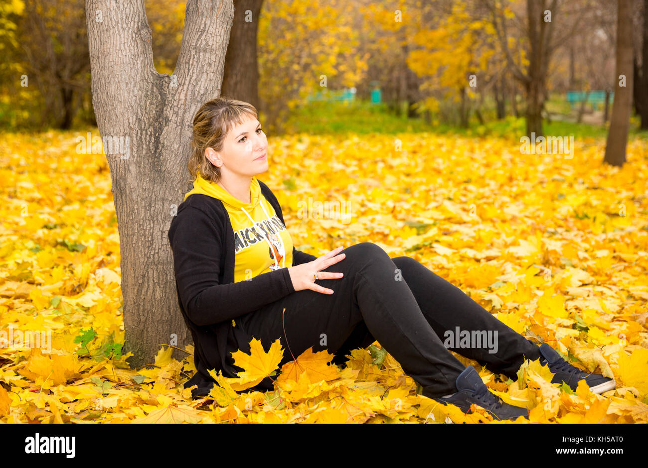 Autumn portrait of beautiful woman over yellow leaves while walking in ...