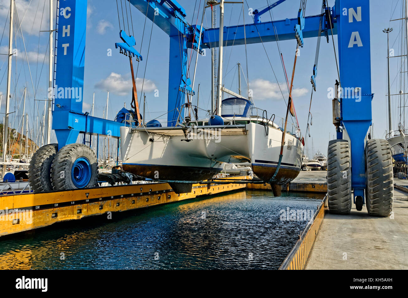 Cruising catamaran being lifted out of the water by marina boat crane.. Stock Photo