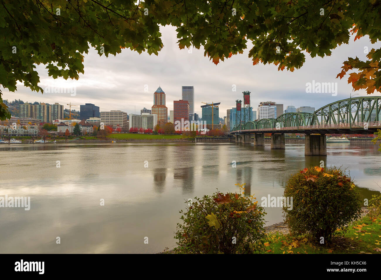 Portland Oregon downtown city skyline framed by fall season foliage along Willamette River Stock Photo