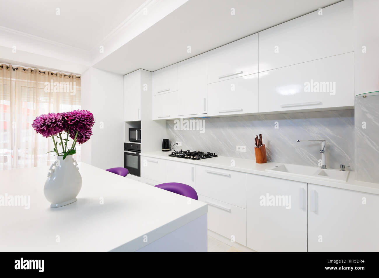 modern kitchen with dining table and purple chairs Stock Photo Alamy