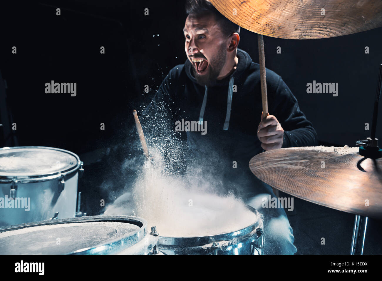 Drummer rehearsing on drums before rock concert. Man recording music on