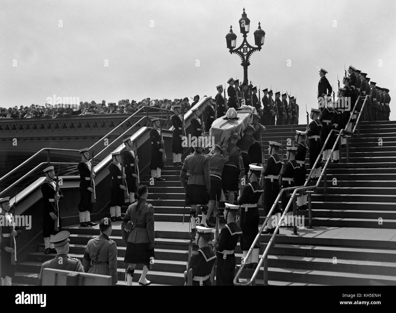 Crowds on Westminster Bridge watch as the flag-draped coffin of Lord Wavell is borne from the Army launch at Westminster Pier. Stock Photo