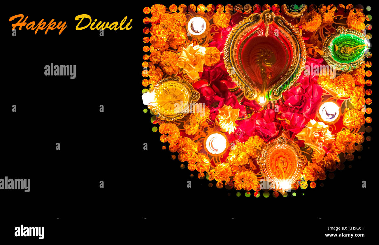 Diwali festival background concept with clay diya lamps floral decorations and rangoli pattern. Stock Photo