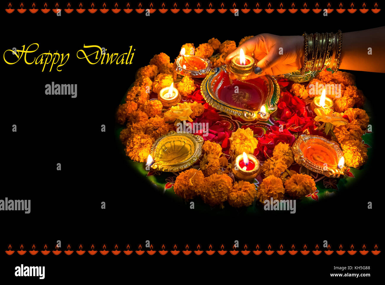 Diwali festival background concept with clay diya lamps floral decorations and rangoli pattern. Stock Photo