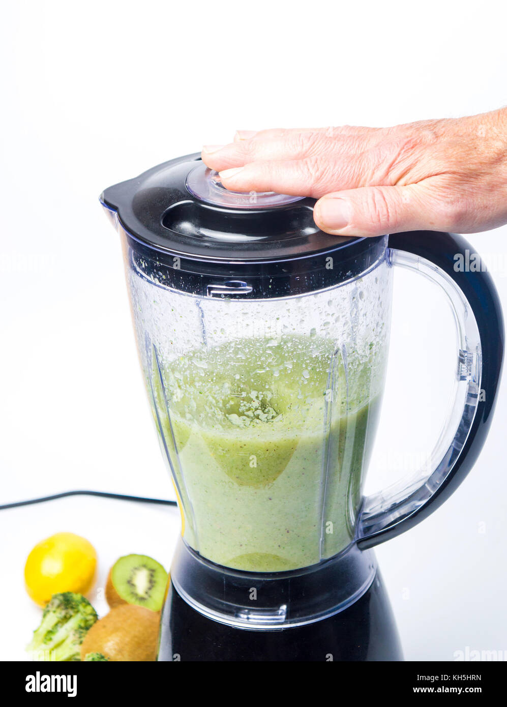 Man making a green smoothie drink in a blender isolated Stock Photo Alamy