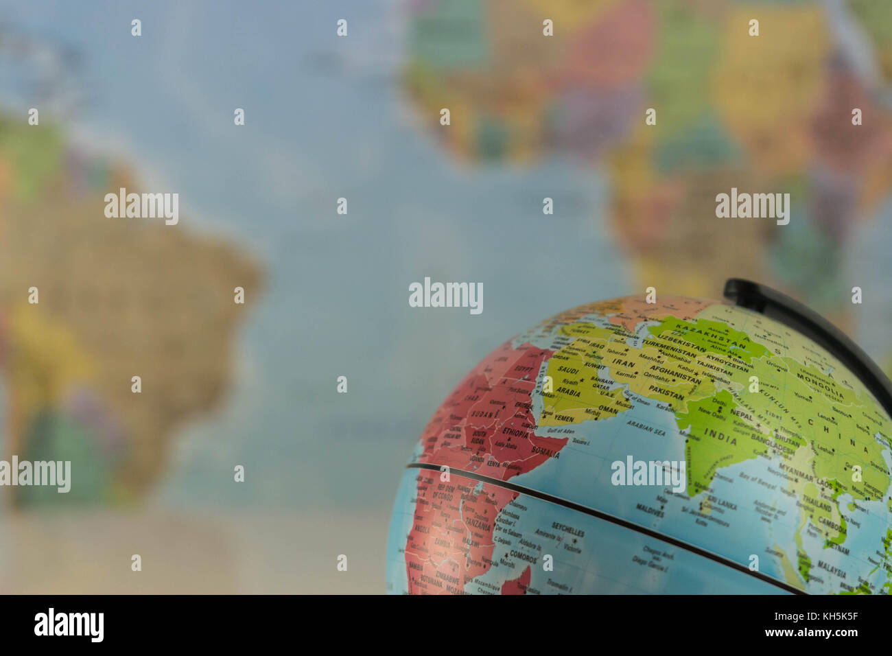 Part of a globe with map of India with blurred map as background. Stock Photo