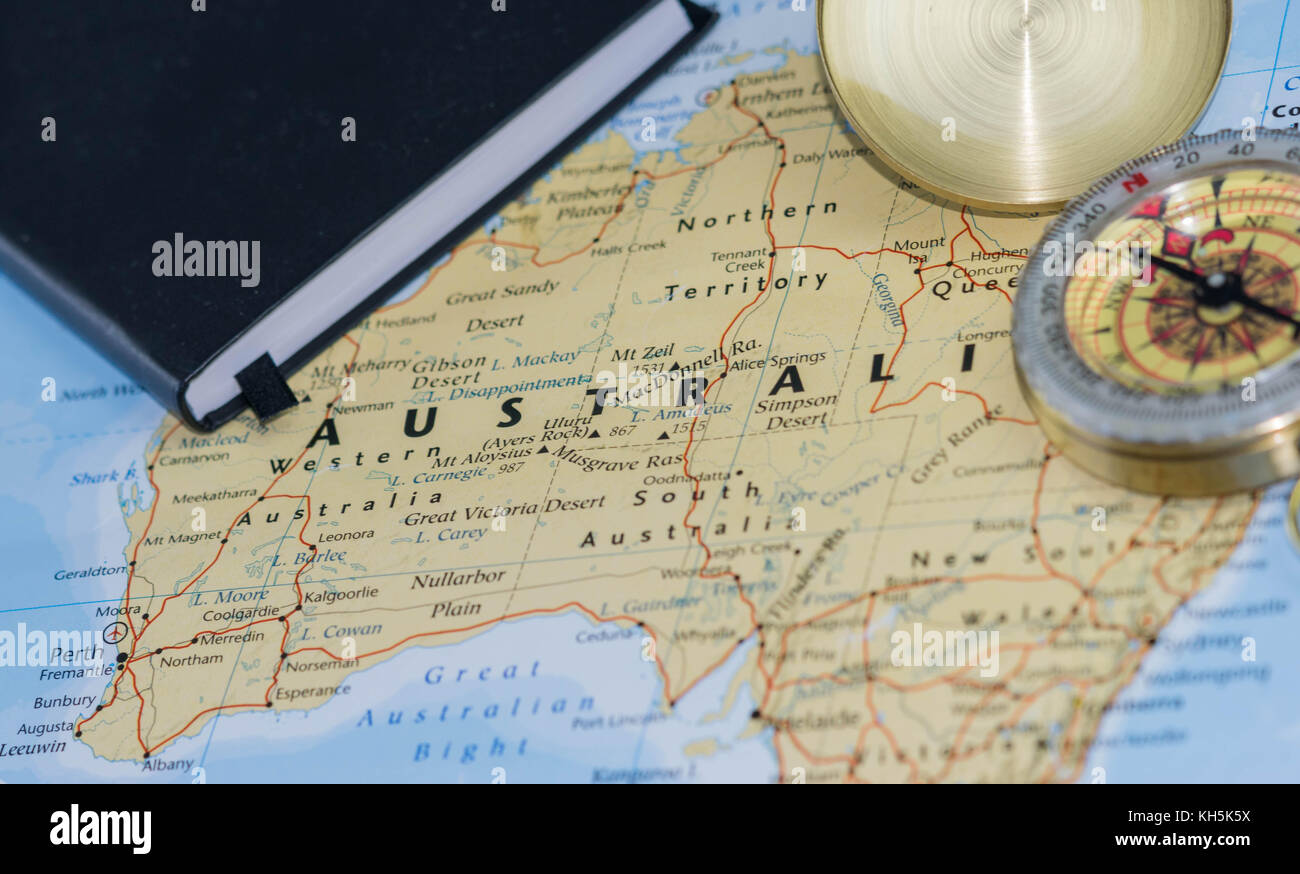 Compass on a close up map pointing at Australia and planning a travel