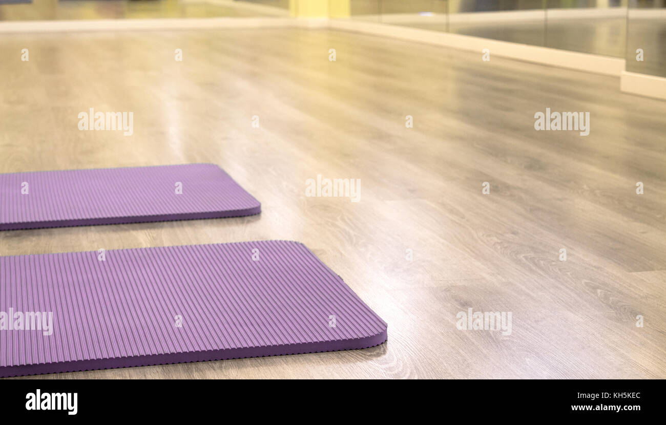 Yoga mat on wooden floor to perform meditation exercises Stock Photo