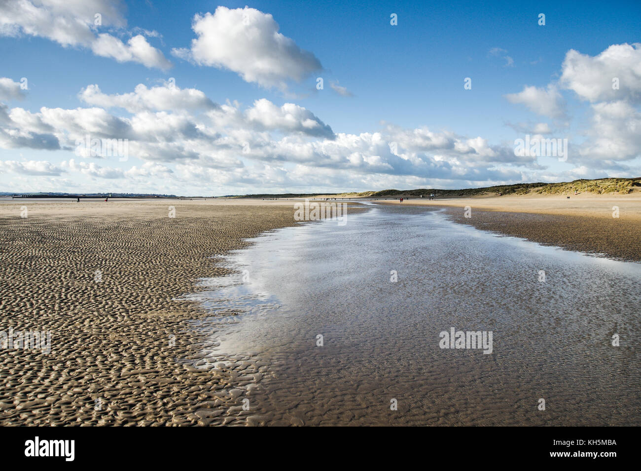Crisp autumnal sky reflecting in water standing on Camber Sands Beach at low tide (East Sussex, England) Stock Photo