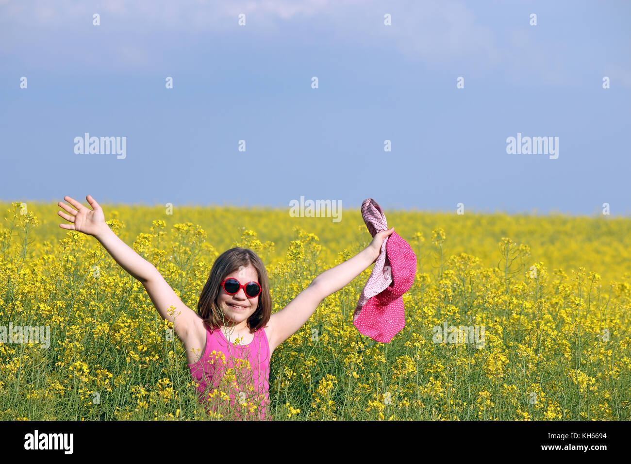 Happy little girl with hands up in yellow field summer season Stock ...
