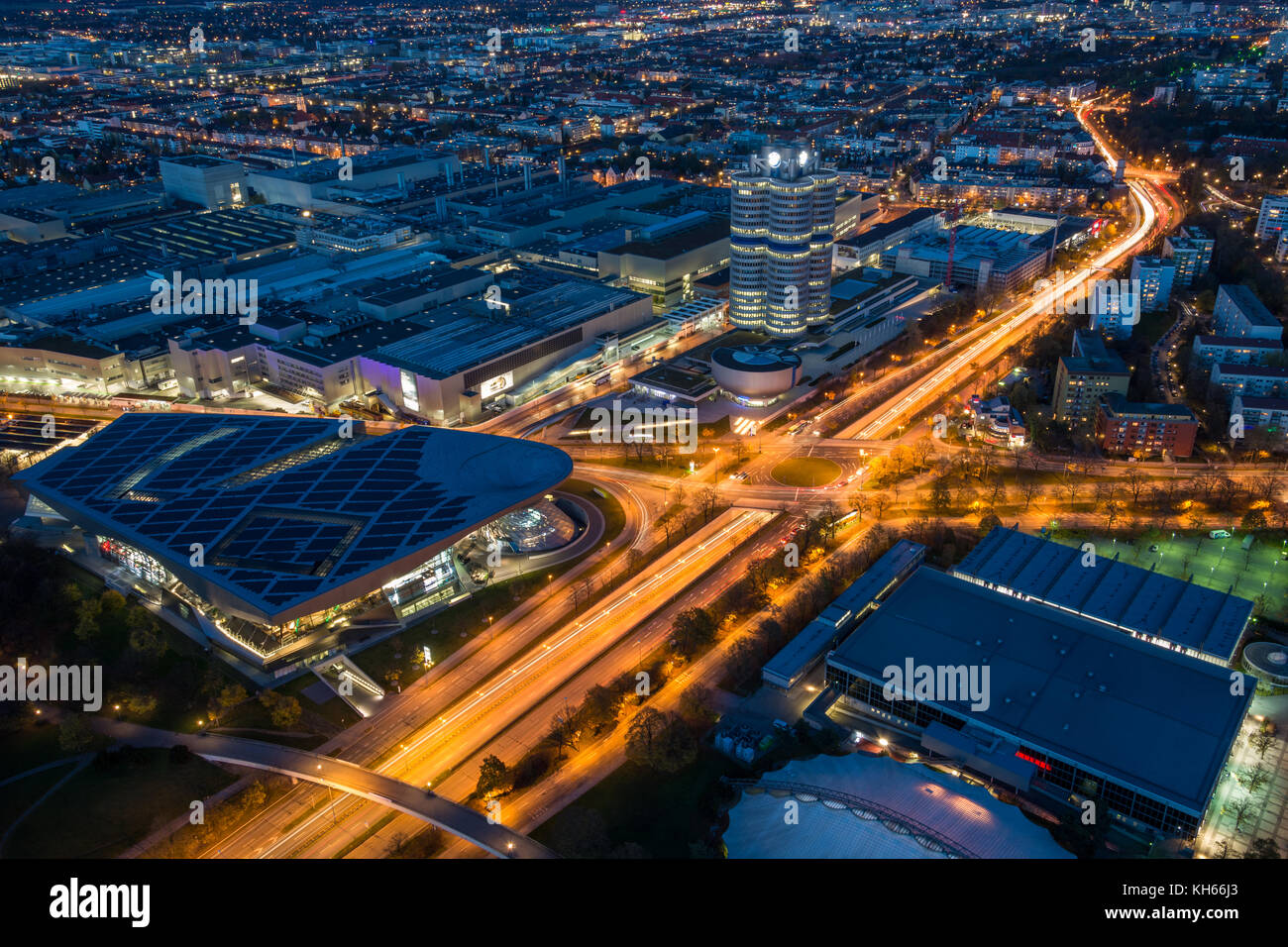 MUNICH, GERMANY - November 3, 2017: The lit BMW headquarters and BMW Welt with light trails from traffic during blue hour from above Stock Photo
