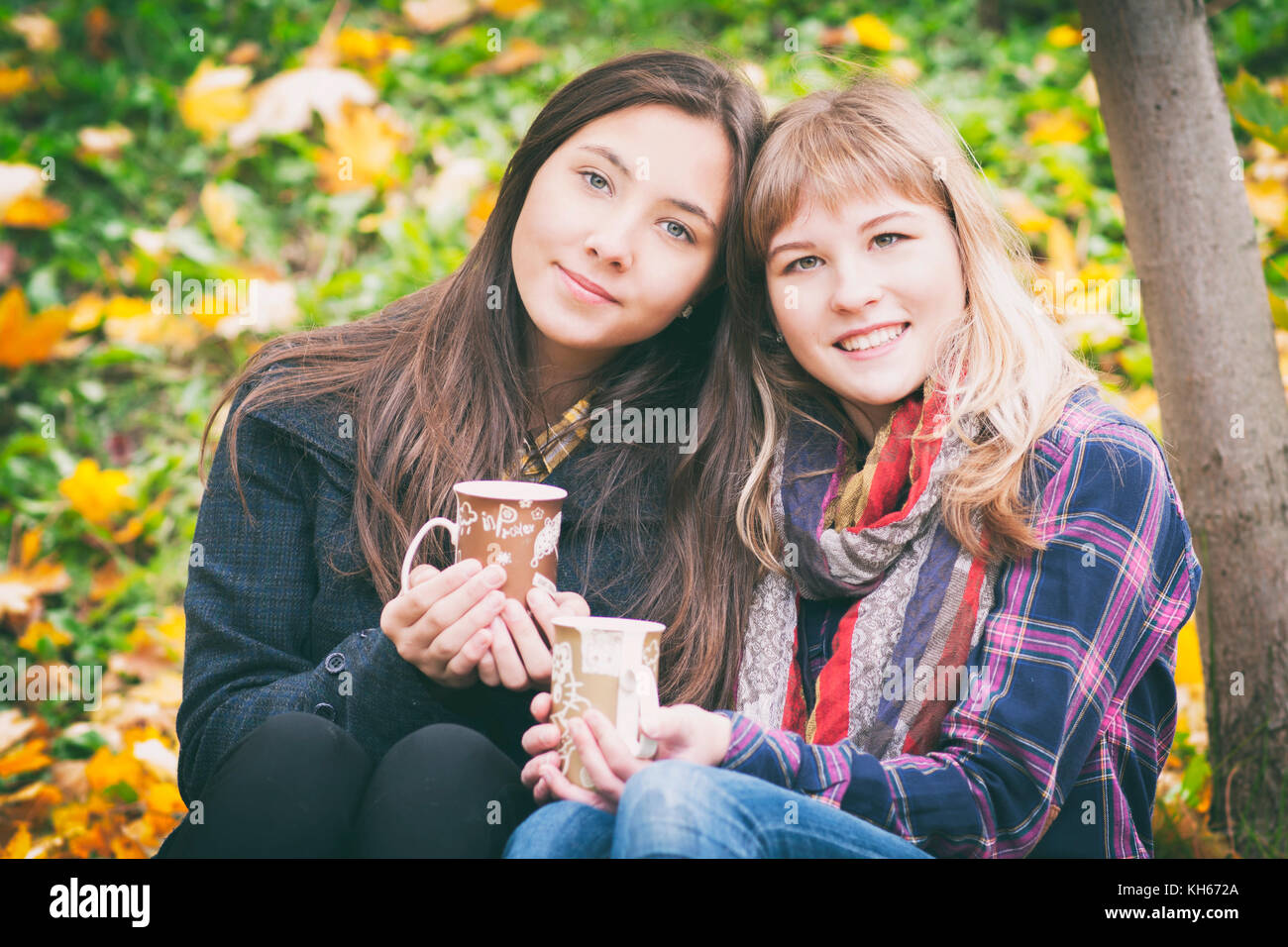 Two young girls on a walk in the autumn park Stock Photo - Alamy