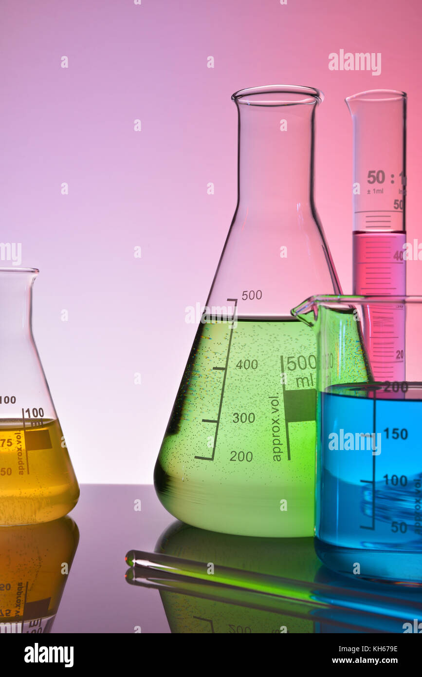Laboratory glass chemical containers on glass table isolated colorful