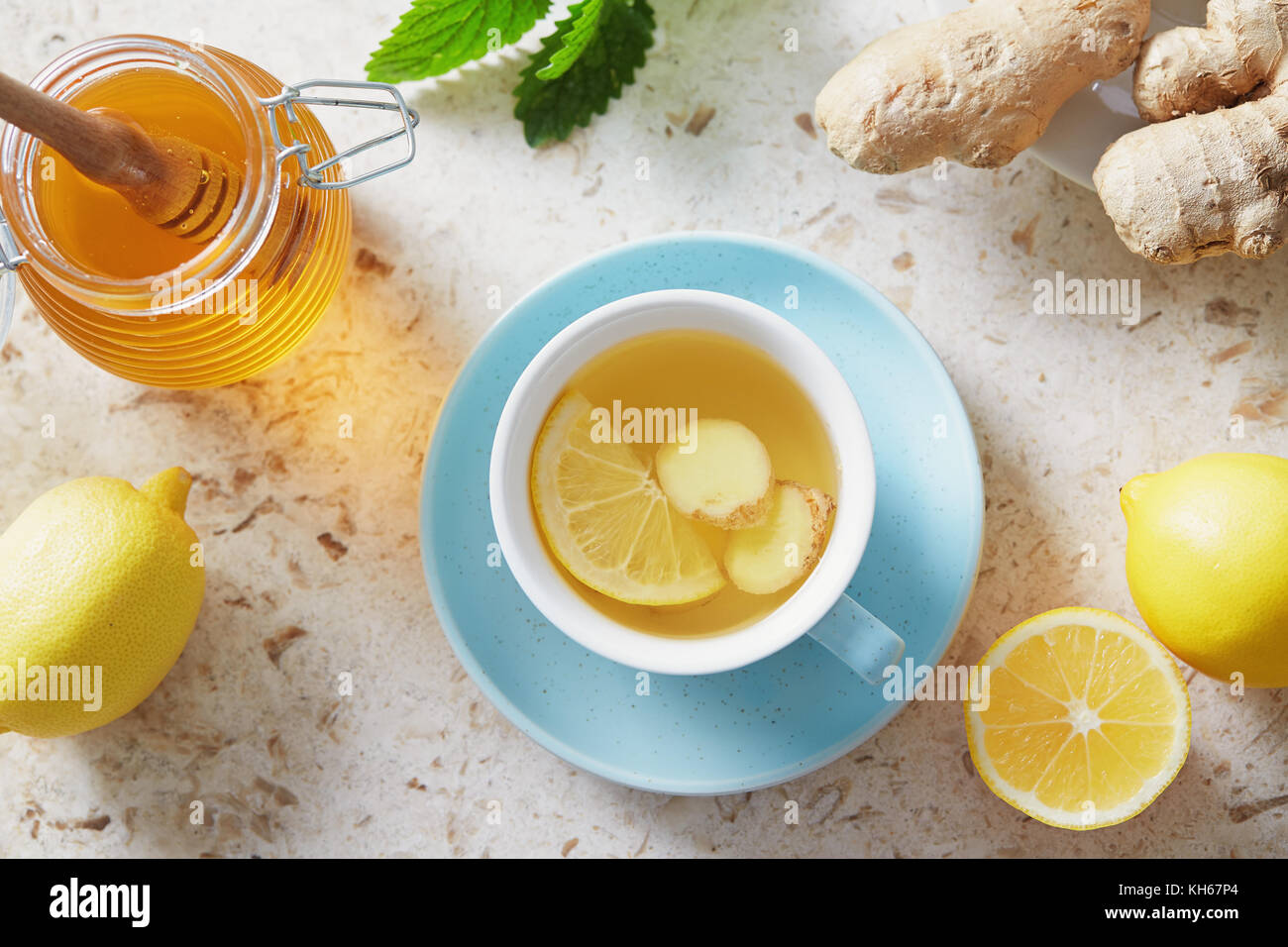 Lemon and ginger tea with honey. Cup of hot honey lemon tea with fresh ginger root. Stock Photo