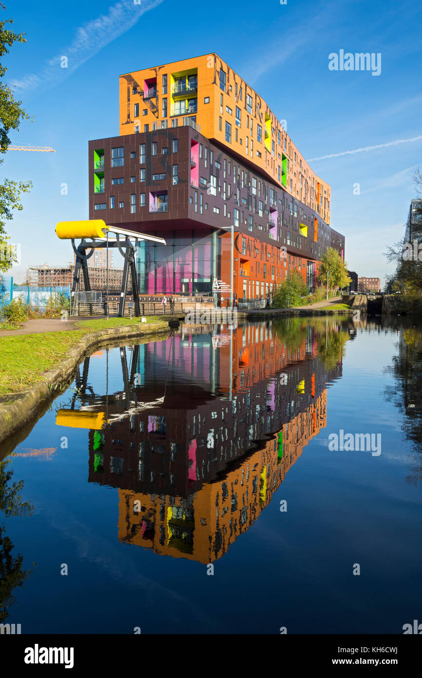 The Chips apartment building, by Will Alsop, and a bascule lifting bridge, reflected in the Ashton Canal, New Islington, Ancoats, Manchester, UK Stock Photo
