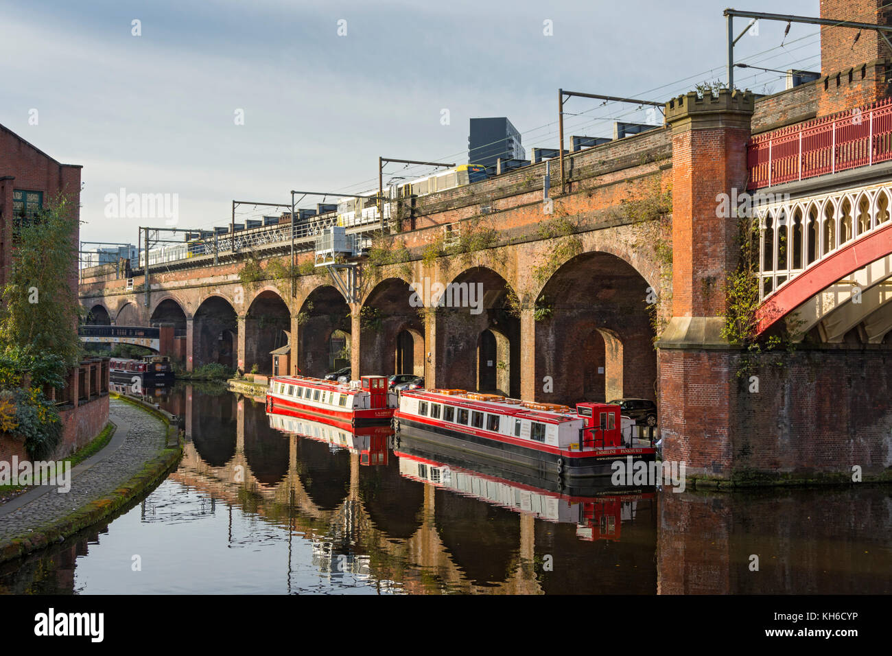 Victorian railway viaduct and canal boats on the Bridgewater Canal at Castlefield Basin, Manchester, England, UK. Stock Photo