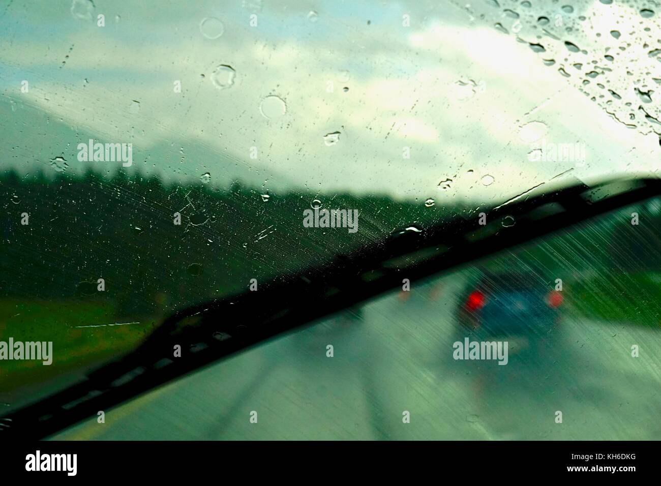 Rainy weather through the car window with the wipers Stock Photo