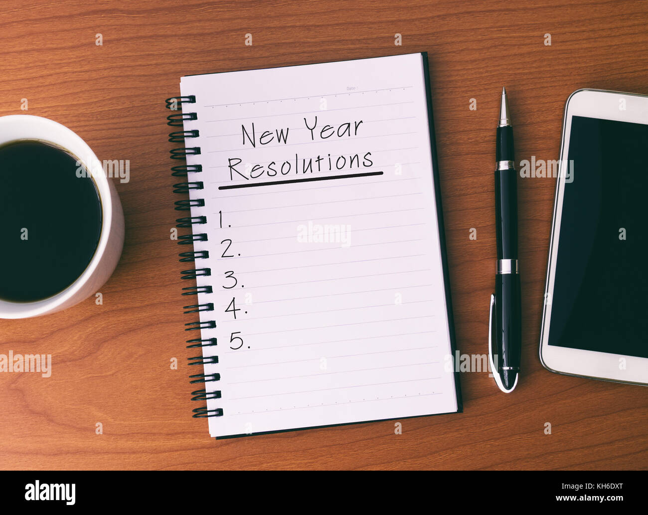 New Year's Resolution List on Notepad, background Coffee, Pen and Smart Phone. Stock Photo