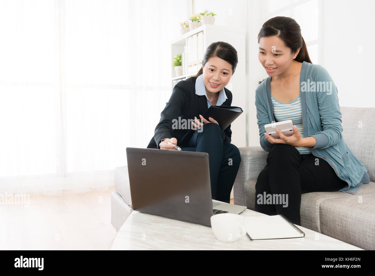 happy smiling woman sitting on sofa couch looking at laptop and using ...