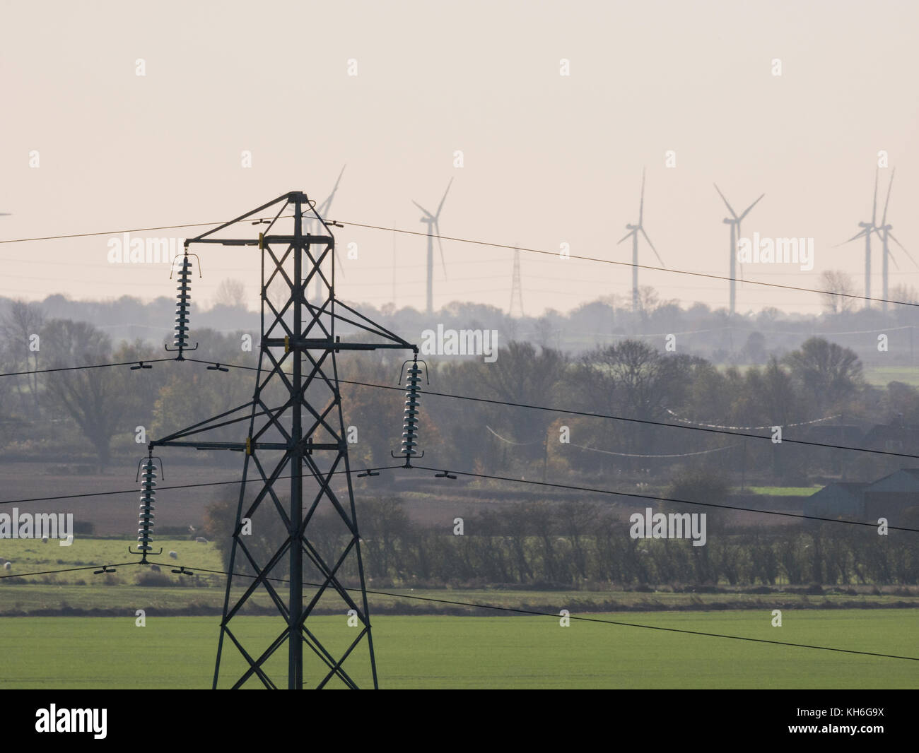 Power lines, with wind turbines in the background Stock Photo - Alamy